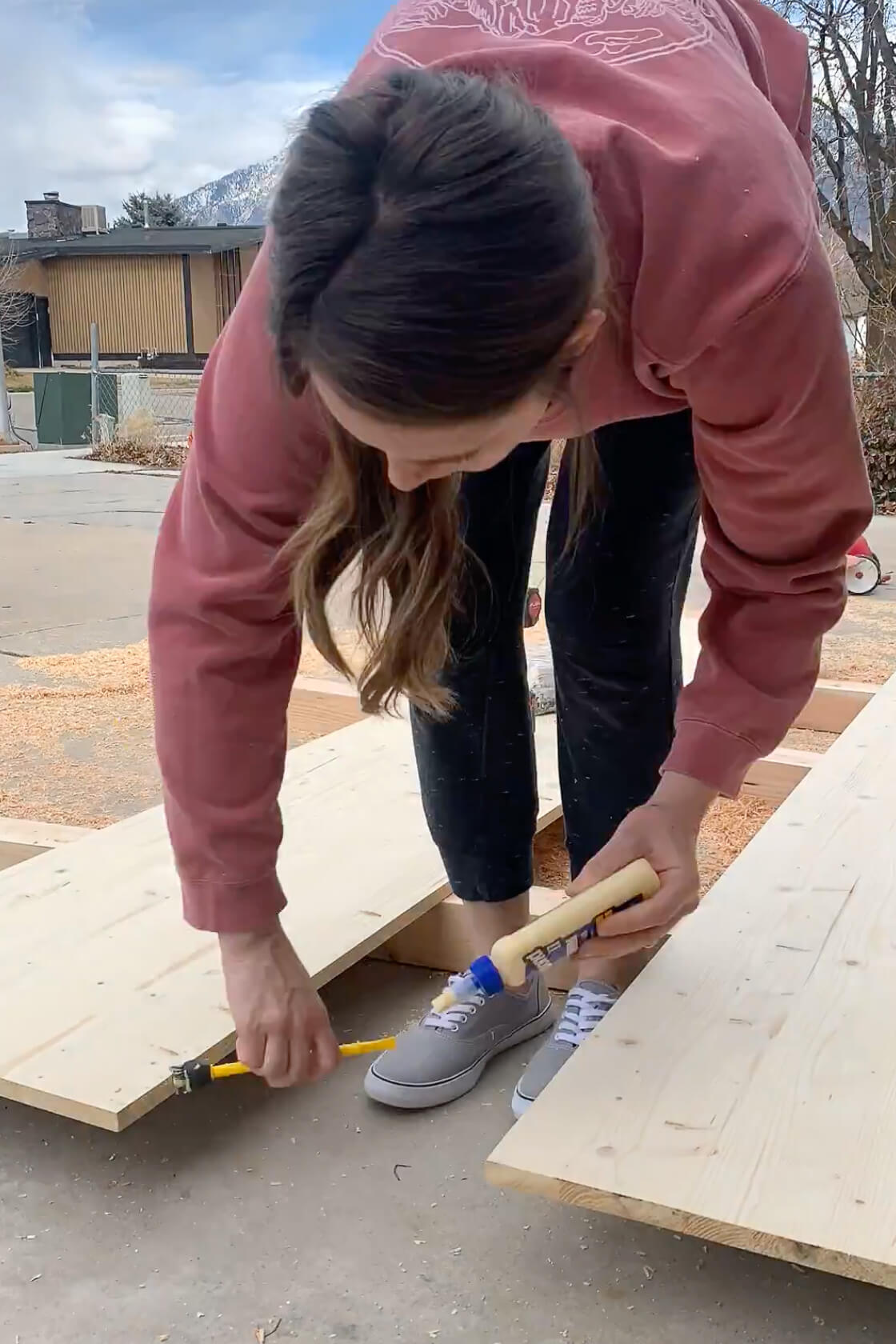 Using wood glue to attach two pieces of wood together for a DIY table top.